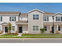 Charming townhome featuring a well-manicured lawn and tasteful exterior color scheme at 6068 Peaceful Pkwy, Clermont, FL 34714