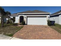 Charming single-story home with a brick driveway and a two-car garage at 622 Samuel Pl, Davenport, FL 33837