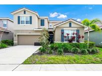 Charming two-story home featuring a well-manicured lawn and a two-car garage at 7587 Oakmoss Loop, Davenport, FL 33837