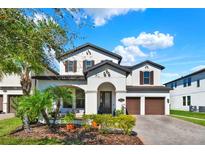 Beautiful two-story home featuring a well-maintained lawn, attached two-car garage, and manicured landscaping at 8330 Vivaro Isle Way, Windermere, FL 34786