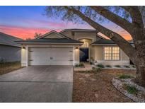 Charming single-story home with a two-car garage, manicured landscaping and lovely curb appeal at sunset at 2234 Rockwood Dr, Apopka, FL 32703