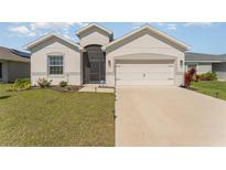 Charming single Gathering home showcasing a well-manicured lawn and a two-car garage at 4115 Ruby Run, Haines City, FL 33844