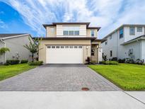 Attractive two-story home with a large driveway, well-maintained lawn, and neutral color scheme at 5266 Buttonsage Dr, St Cloud, FL 34772