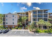 Multi-story condo building with balconies, palm trees and parking at 9051 Treasure Trove Ln # 505, Kissimmee, FL 34747