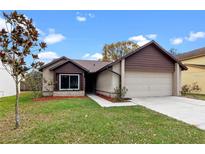 Charming single-Gathering home featuring a well-maintained front yard and a two-car garage at 1080 Abell Cir, Oviedo, FL 32765