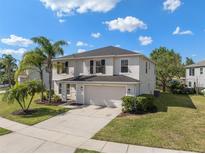 Charming two-story home featuring an attached two-car garage and a well-maintained lawn with tropical landscaping at 12621 Oulton Cir, Orlando, FL 32832