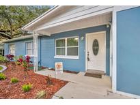 Charming blue home featuring a white front door, landscaped yard and a 'Welcome' sign at 1416 E 20Th St, Sanford, FL 32771