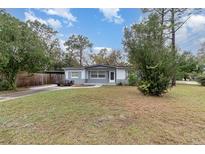 Charming single-story home featuring a spacious front yard, gray exterior, and covered carport at 200 Avenue C, Chuluota, FL 32766