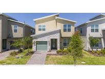 Modern two-story home with stone accents, manicured lawn, and a green two car garage door at 540 Sticks St, Davenport, FL 33896