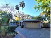 Charming single-story home featuring a two-car garage, blue facade, and meticulous landscaping at 621 Daron Ct, Winter Springs, FL 32708