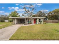 Charming single-story home with a well-maintained lawn and vibrant red front door at 704 Baywood Dr, Sanford, FL 32773