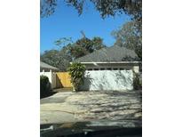 Detached garage with a white door, grey roof, and adjacent new wood fence at 7314 Seena Ct, Orlando, FL 32835