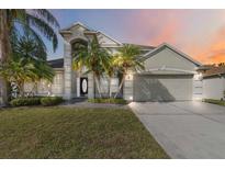 Charming two-story home featuring a neutral color palette, two-car garage, and lush tropical landscaping at 965 Rosinia Ct, Orlando, FL 32828