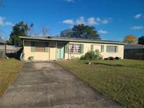 Charming single-story home with a well-maintained lawn and a concrete driveway, perfect for parking convenience at 1215 Marie Ave, Apopka, FL 32703