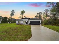 Modern home featuring a spacious lawn, two-car garage, and contemporary black and white design at 2252 Sw 168Th Loop, Ocala, FL 34473