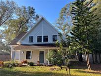Charming two-story home boasts a bright exterior, lush landscaping, and inviting front porch at 25704 Aberdovey Ave, Sorrento, FL 32776