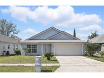 Charming single-story home featuring a well-maintained lawn and attached two-car garage at 2740 Regency Oak Ln, Orlando, FL 32833