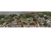 Large waterfront property with red boundary lines, lush greenery, and dock access showcasing prime real estate potential at 3540 Walker Rd, Apopka, FL 32703