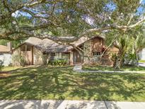 Charming single-Gathering home with a stone and wood facade, mature trees, and a well-maintained lawn at 685 Vistawilla Dr, Winter Springs, FL 32708