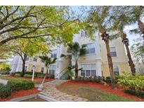 Inviting condo building with lush landscaping, mature trees, and accessible entry features at 8929 Legacy Ct # 106, Kissimmee, FL 34747