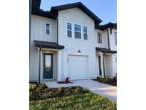 Charming, two-story townhome featuring a one-car garage, and a beautifully landscaped front yard at 925 Conch Rd, Davenport, FL 33896