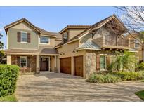 Beautiful home featuring a stone facade, 3-car garage, and a welcoming paver driveway at 11507 Center Lake Dr, Windermere, FL 34786