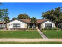 Charming home featuring stone accents, manicured lawn, and inviting curb appeal at 207 Pembrook Pl, Longwood, FL 32779