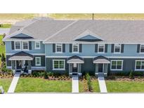 Stylish two-story townhomes with gray siding, a well-manicured lawn, and inviting front entrances at 2676 Gouda Dr, Apopka, FL 32703