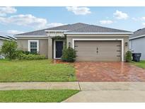 Charming single-story home featuring a brick driveway, neutral paint, and a well-maintained lawn at 841 Benjamin Trl, Davenport, FL 33837