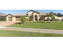 Charming single-story home featuring a manicured lawn and a three-car garage at 9716 Royal Vista Ave, Clermont, FL 34711