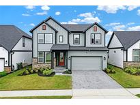 Two-story home boasts a modern exterior with gray siding, stone accents, and a well-manicured front lawn at 17052 Cercis Loop, Clermont, FL 34711