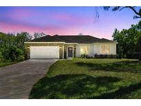 Charming single-story home featuring a two-car garage, stone accents, and a well-manicured lawn at 1870 Blackwelder Rd, De Leon Springs, FL 32130