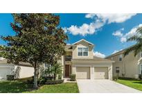 Charming two-story home featuring a well-manicured lawn and a spacious two-car garage at 2683 Manesty Ln, Kissimmee, FL 34747