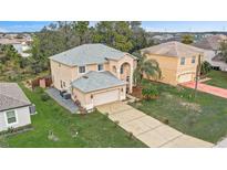 Two-story home with a neutral color palette, well-manicured lawn, and a long driveway at 548 Big Sioux Ct, Kissimmee, FL 34759