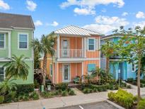 Charming, colorful two-story home with a balcony, complemented by lush tropical landscaping at 8086 Knee Deep Rd, Kissimmee, FL 34747