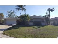 Charming single-story home with a well-manicured lawn and lush tropical landscaping at 103 Blue Heron Ln, Casselberry, FL 32707