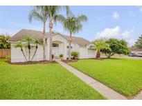 Inviting single-story home featuring lush landscaping and a well-manicured lawn at 1145 Lake Rogers Cir, Oviedo, FL 32765