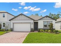 Charming single-Gathering home with a brick driveway, a well-manicured lawn, and stylish exterior paint at 360 Birkdale Dr, Daytona Beach, FL 32124