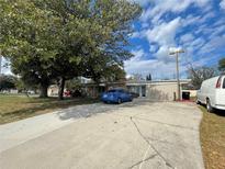 Charming single-story home with a well-maintained lawn, and a blue sedan in the driveway at 4007 Clarcona Ocoee Rd, Orlando, FL 32810