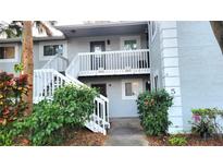 Exterior view of a two-story condo with white stairs and well-maintained landscaping at 4164 Plantation Village Condos Dr # 504, Orlando, FL 32810