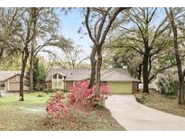 Charming single-story home with brick facade, green garage door, and mature landscaping at 5849 Groveline Dr, Orlando, FL 32810