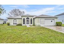 Quaint single story house with green grass in the front yard and an attached garage at 609 Bluebill Ln, Kissimmee, FL 34759