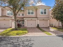 Charming townhouse featuring a tile roof, brick driveway, and well-maintained landscaping at 1205 Bella Rose Ct, Davenport, FL 33896