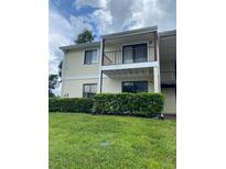 Two-story condo featuring a second-story balcony with painted siding and well-maintained green space at 314 Cherokee Ct # A, Altamonte Springs, FL 32701
