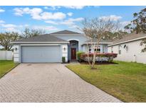 Charming single-story home featuring a brick-paved driveway and a well-manicured front lawn at 3733 Pyrite Dr, Orlando, FL 32826