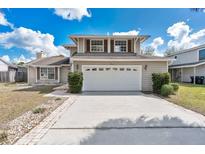 Charming two-story home featuring a two-car garage, neutral siding, and a well-manicured front yard at 3921 Stonehaven Rd, Orlando, FL 32817