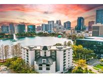 Striking aerial view of the condo building overlooking a picturesque lake and the vibrant downtown skyline at 401 E Robinson St # 101, Orlando, FL 32801
