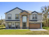 Charming two-story home with well-manicured lawn, covered porch, and attached two-car garage at 5217 Dallas Blvd, Orlando, FL 32833