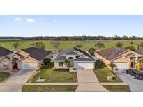 Charming home with a well-manicured lawn and view of a green pasture behind the houses at 5425 Bryce Canyon Dr, Kissimmee, FL 34758