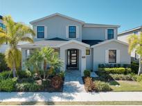 Beautiful two-story home with a lush landscaped yard and welcoming front porch at 7464 Gathering Dr, Reunion, FL 34747
